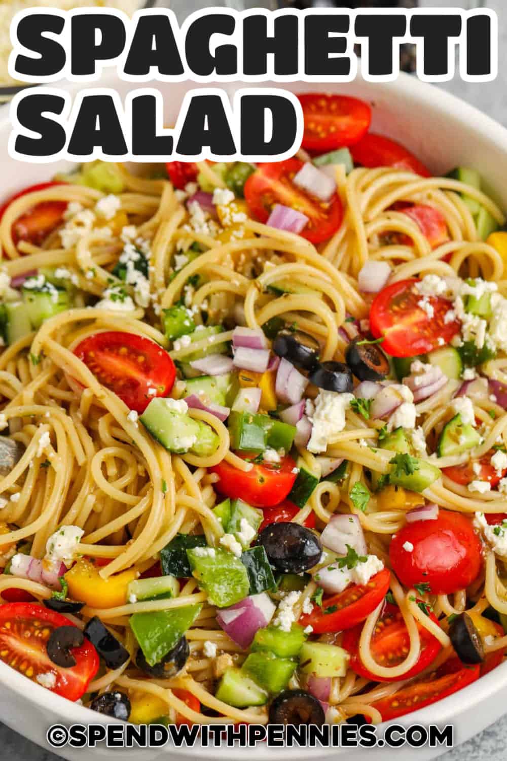 Spaghetti salad is a fun twist on classic pasta salad with long tender noodles and lots of crisp vegetables. Grape tomatoes add sweetness, cucumber adds crunch, bell pepper brings color, and feta gives every bite a salty finish. Chill it before serving so the dressing can soak into the pasta, then toss again for a fresh and flavorful side dish. Pin this easy pasta salad for your next cookout. #spendwithpennies Spaghetti Salad with feta and a title