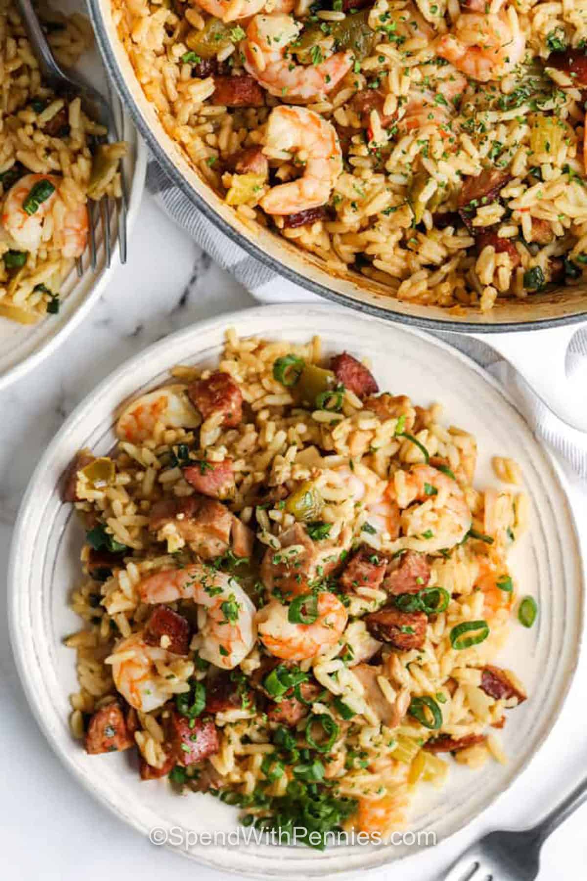Make this Cajun jambalaya recipe when you want a filling dinner with chicken, andouille sausage, shrimp, vegetables, and fluffy seasoned rice. Parboiled rice helps prevent a mushy texture, and the shrimp is added at the end so it stays tender. It is a practical meal for busy nights, casual company, or make-ahead lunches. Save this for your next meal. #spendwithpennies cajun jambalaya on a plate