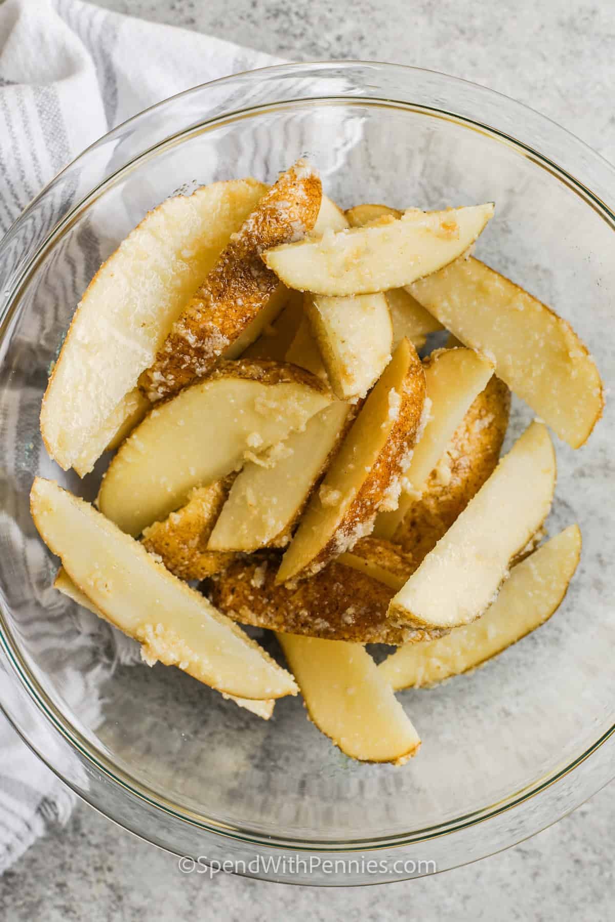 bowl of seasoned potato wedges to make Crispy Baked Potato Wedges