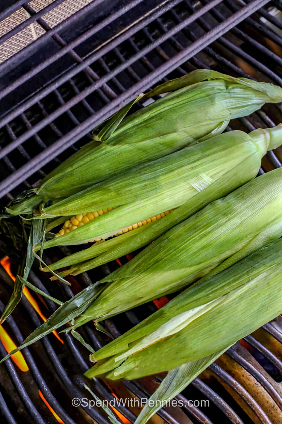 cooking corn on a grill in the husks to make Grilled Corn on the Cob