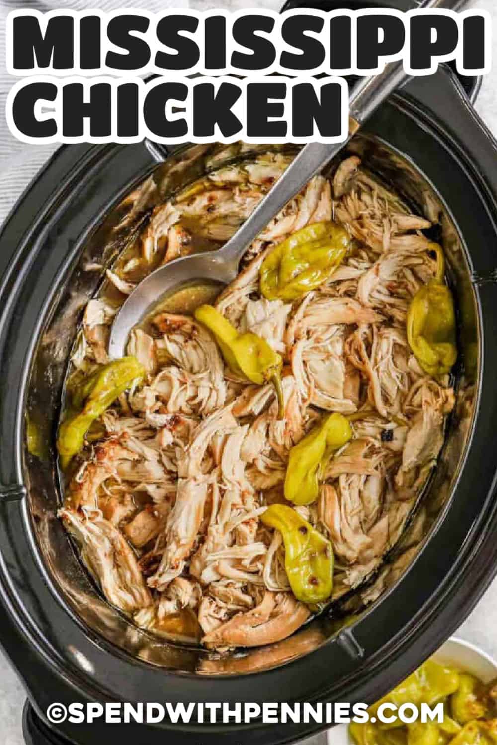 This Crock Pot Mississippi chicken recipe uses just a few ingredients to make tender, flavorful shredded chicken. Pepperoncini juice adds the perfect tang, while ranch seasoning, au jus, and butter create a rich sauce that tastes great over potatoes or tucked into sandwich buns. It is a hands-off slow cooker meal that works for family dinners or meal prep. Pin this recipe for your next meal. #spendwithpennies crock pot of Mississippi Chicken with a title