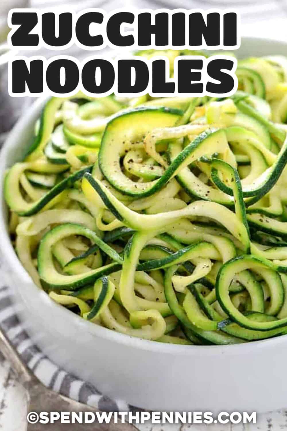 Learn how to make zucchini noodles with a spiralizer and cook them without losing their fresh texture. These zoodles need only olive oil, Italian seasoning, optional butter, and a few minutes in a hot nonstick skillet. Adding salt after cooking helps prevent excess water, while the medium spiralizer blade creates sturdy strands. Pin this easy zucchini noodle recipe on your sides board for any favorite pasta sauce. #spendwithpennies bowl of Zucchini Noodles with a title