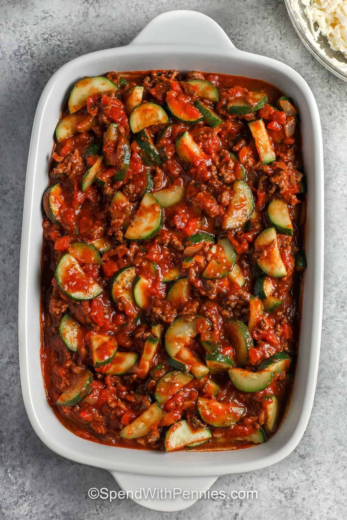 adding ingredients together in casserole dish to make Zucchini Hamburger Casserole