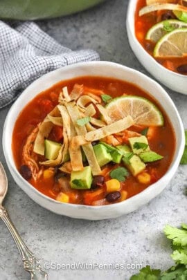 bowls of Chicken Tortilla Soup with lime and avocado on top.