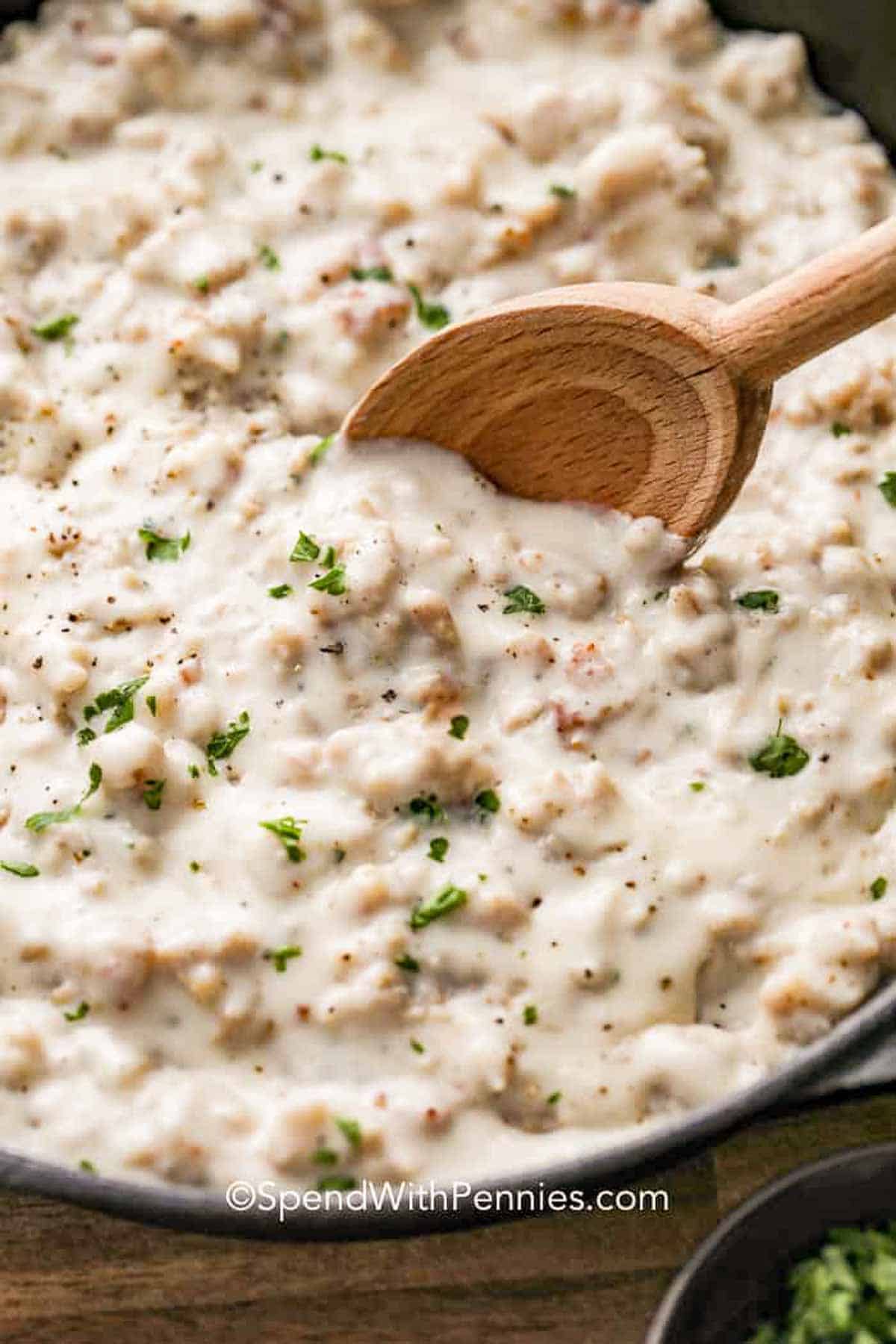 mixing Sausage Gravy Recipe with a wooden spoon