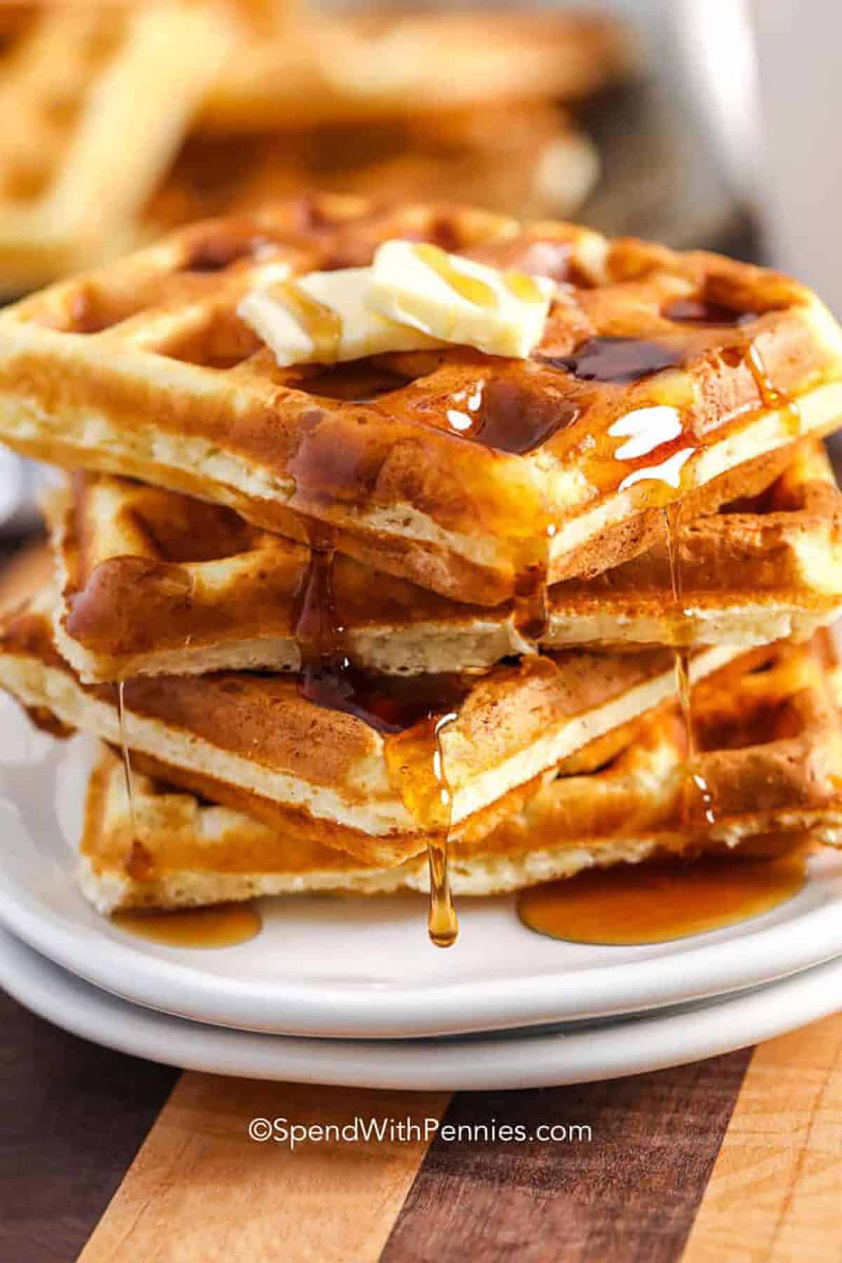 This waffle recipe makes the kind of breakfast everyone looks forward to, with crisp golden edges, soft centers, and warm vanilla flavor. Whipped egg whites help the batter cook up especially light and fluffy, while melted butter adds richness to every bite. Serve these homemade waffles with maple syrup, fresh berries, or whipped cream for a cozy breakfast or brunch. Save this easy recipe and make a batch this weekend. #spendwithpennies fluffy Waffle Recipe in a stack on a plate