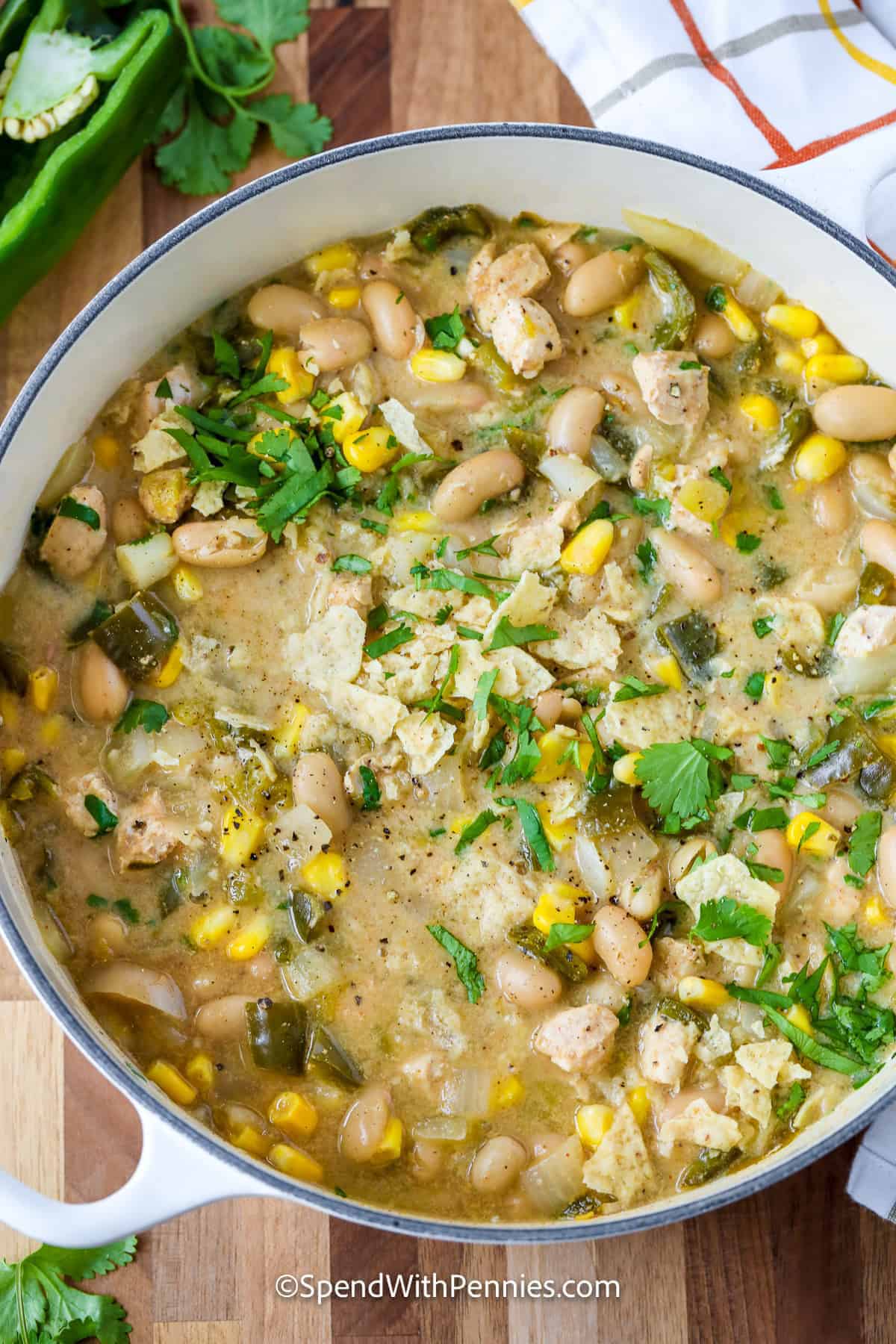 Easy white chicken chili makes a practical meal-prep dinner with chicken breast, cannellini beans, corn, poblano peppers, and green chiles simmered in one pot. The beans make it hearty, sour cream gives the broth a smooth finish, and the toppings can be stored separately so leftovers stay fresh. It reheats well for an easy lunch or dinner later in the week. Pin this creamy chicken chili recipe for your next meal-prep day. #spendwithpennies pot of White Chicken Chili.