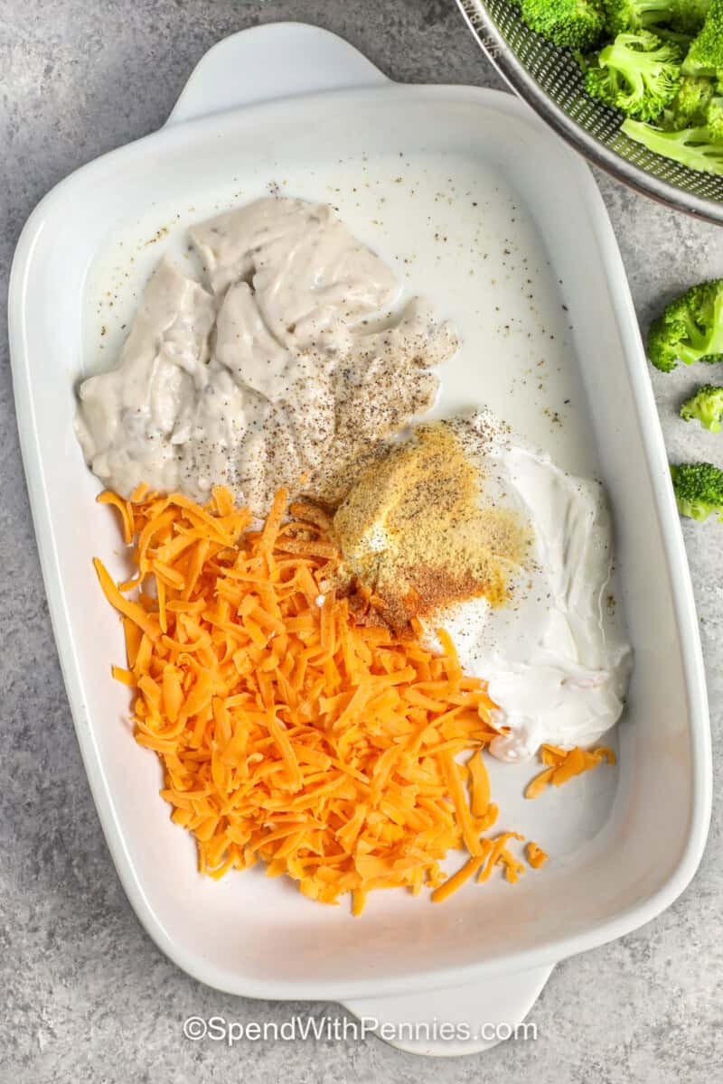 adding ingredients to dish to make Chicken Divan.