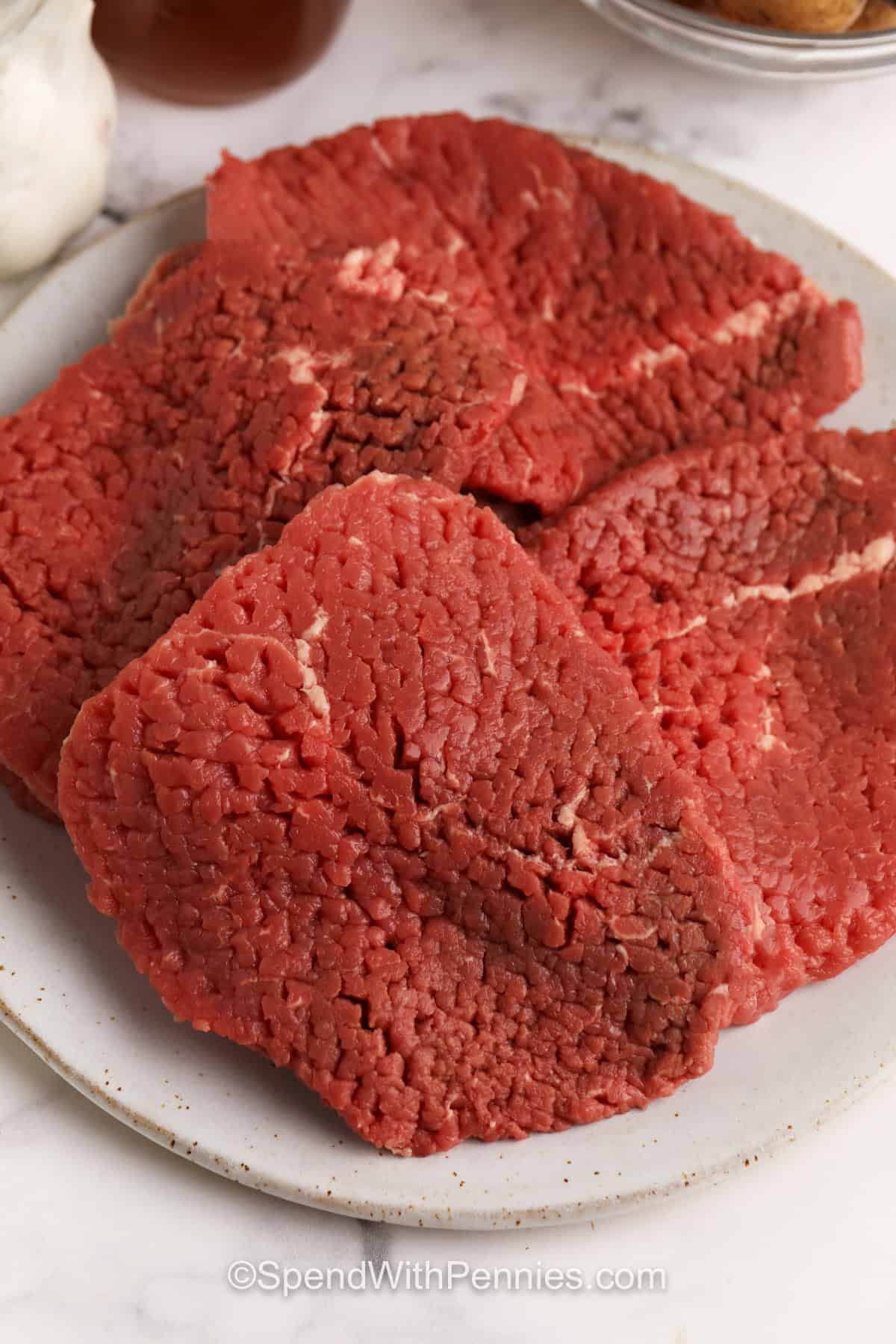 cube steaks on a plate to make Crock Pot Steak and Gravy