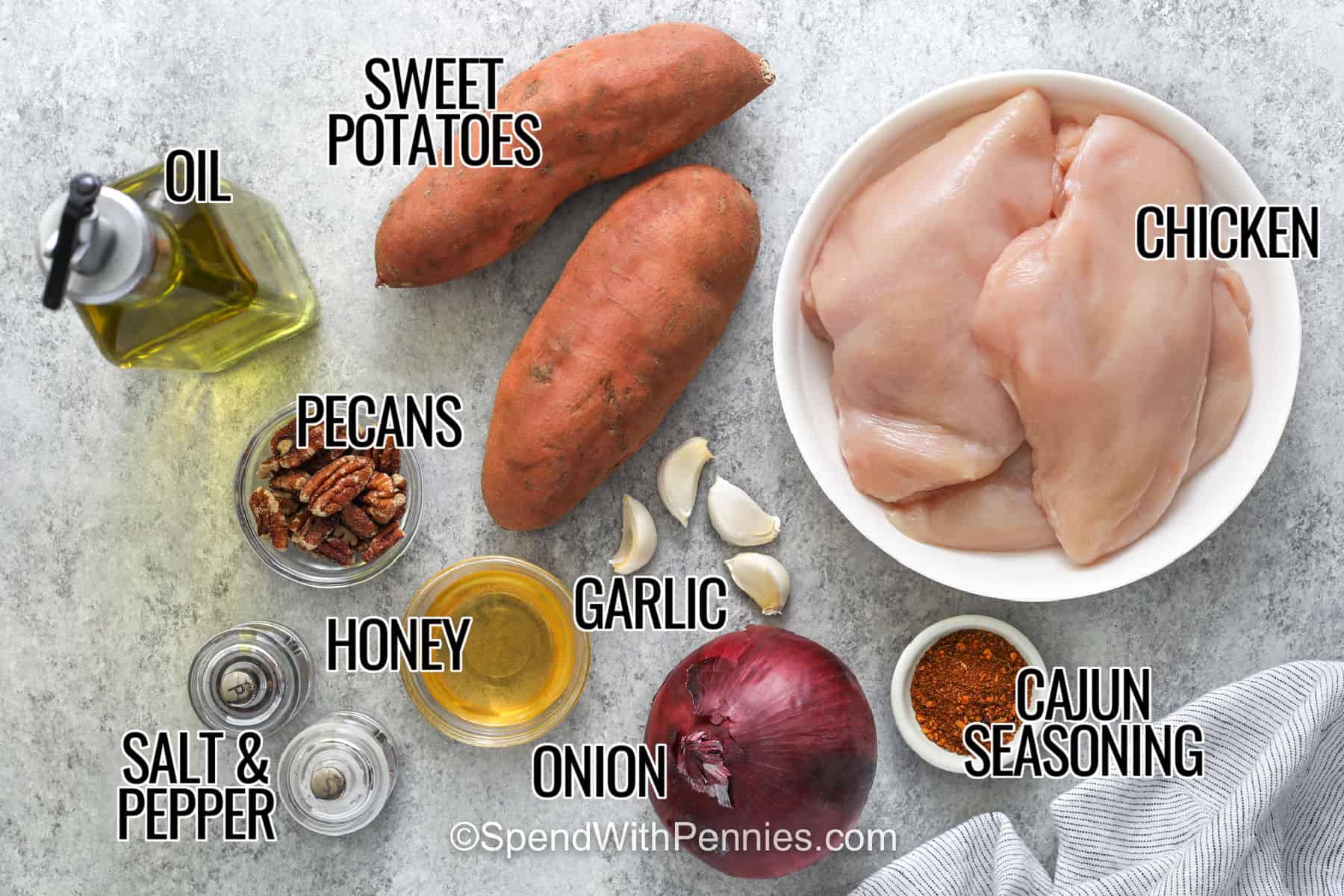 This Cajun chicken and sweet potatoes recipe turns familiar ingredients into a cozy one-pan meal. Sweet potatoes become tender with lightly caramelized edges while boneless chicken breasts roast with bold Cajun seasoning. Honey ties the sweet and savory flavors together, and red onion and garlic add even more roasted flavor. Save this chicken sweet potato sheet pan dinner for an easy meal with minimal cleanup. #spendwithpennies sweet potatoes , chicken , cajun seasoning , onion , garlic, honey , pecans , oil , salt and pepper with writing to make Sheet Pan Chicken and Sweet Potatoes