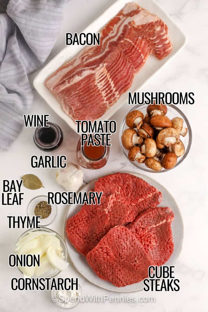 Crock Pot steaks and gravy is a comforting slow cooker dinner that transforms cube steak into fork-tender beef with rich homemade gravy. Bacon, onions, mushrooms, herbs, and beef broth slowly cook together for incredible flavor. Serve over mashed potatoes, egg noodles, or rice for an easy family meal that reheats beautifully. Save this recipe for your next cozy dinner. #spendwithpennies bacon , mushrooms , tomato paste , wine , garlic , rosemary , bay leaf , thyme , onion , cornstarch , cube steaks with labels to make Crock Pot Steak and Gravy