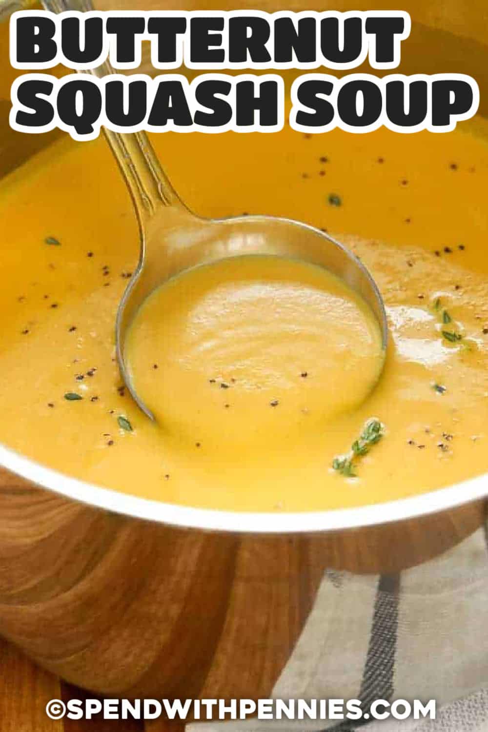 Homemade butternut squash soup makes a comforting fall lunch, dinner, or holiday starter using simple ingredients. Roasted butternut squash provides a naturally creamy base, while apple, sage, thyme, and optional curry powder add layers of sweet and savory flavor. Blend everything until silky and finish with cream to taste. Pin this soup recipe for an easy meal to make all season. #spendwithpennies taking a ladle full of Butternut Squash Soup out of the pot with a title