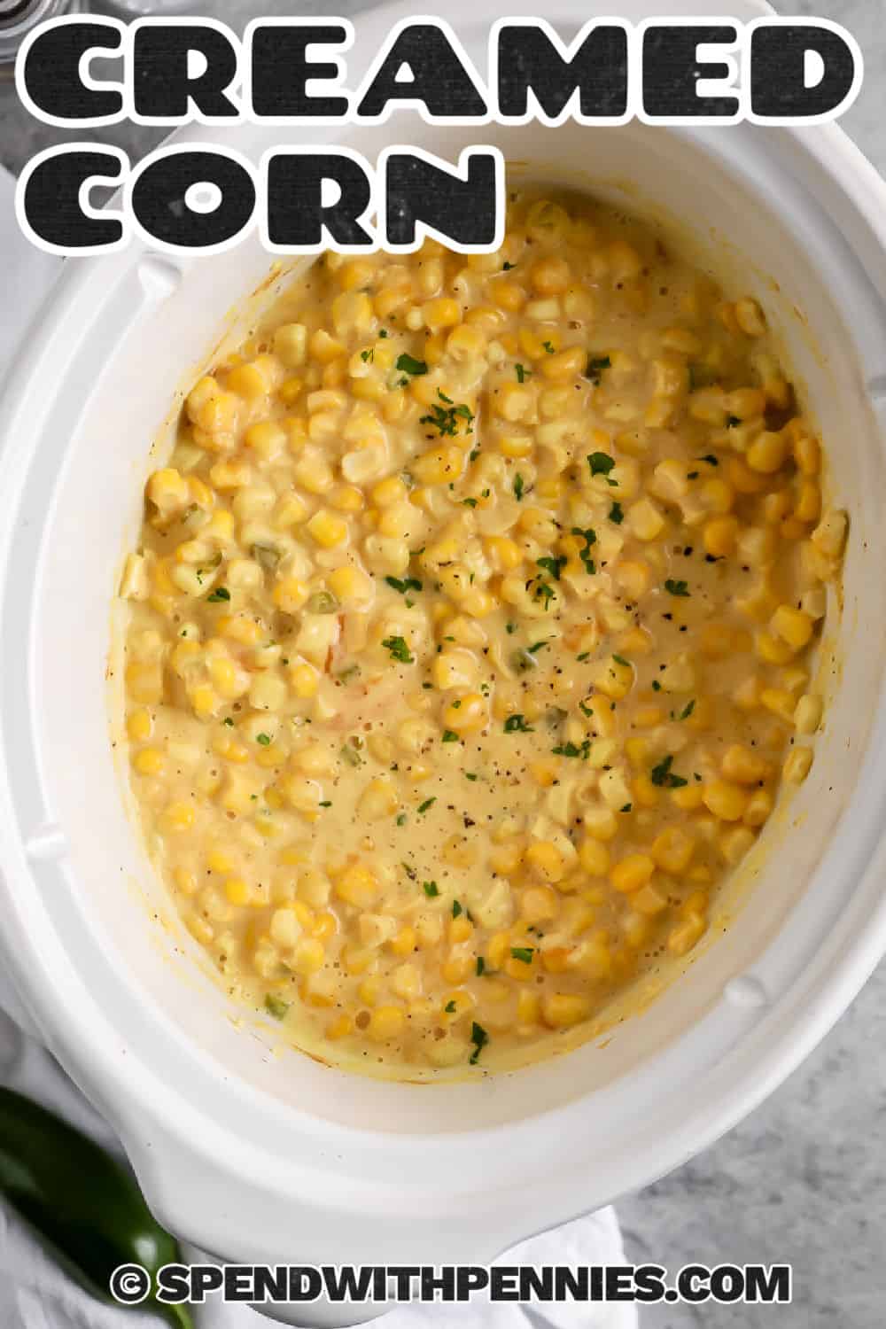 Crock pot creamed corn is a rich and comforting side made with sweet frozen corn, cream cheese, butter, milk, and cheddar. Blending some of the corn creates a velvety sauce while leaving plenty of whole kernels for texture. The slow cooker keeps the oven free, making this a practical choice for Thanksgiving, Christmas, or Sunday dinner. Save this easy recipe for your next holiday meal. #spendwithpennies Crock Pot Creamed Corn in the crockpot with a title.
