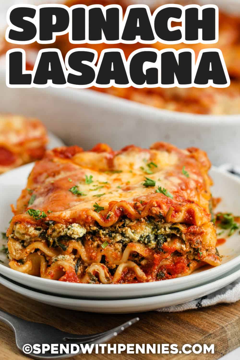 spinach lasagna on a white plate with writing.