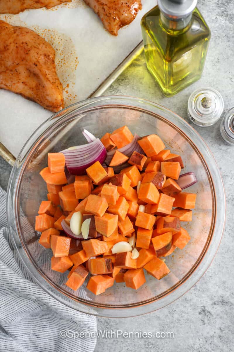 adding ingredients together in bowl to make Sheet Pan Chicken and Sweet Potatoes