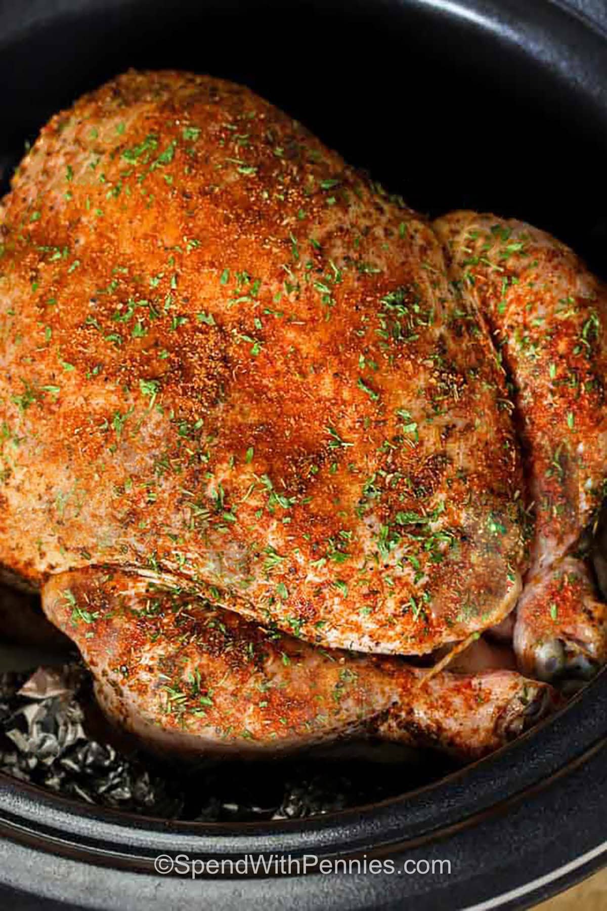 Slow cooker whole chicken and gravy makes an oven-free dinner with tender meat and classic roast-style flavor. Smoked paprika adds depth, thyme and parsley provide a familiar herb flavor, and the onion beneath the chicken seasons the cooking juices. Broiling the cooked chicken is optional, but it gives the skin a golden finish before carving. Turn the drippings into gravy and serve with your favorite sides. Save this recipe for Sunday supper. #spendwithpennies tender Slow Cooker Whole Chicken & Gravy in the cooker
