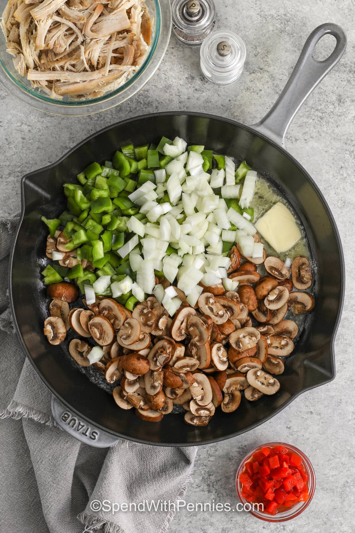 Turkey a la king is a delicious way to turn cooked turkey into a cozy family meal. Tender turkey, mushrooms, peas, peppers, and pimentos are simmered in a rich, creamy sauce for plenty of homemade flavor. Spoon this easy turkey dinner over rice, pasta, or biscuits for a filling meal that everyone will love. Best of all, it comes together in one skillet for easy cooking and cleanup. Add this comforting recipe to your dinner menu. #spendwithpennies adding onions mushroom pepper to melted butter to make Turkey A La King