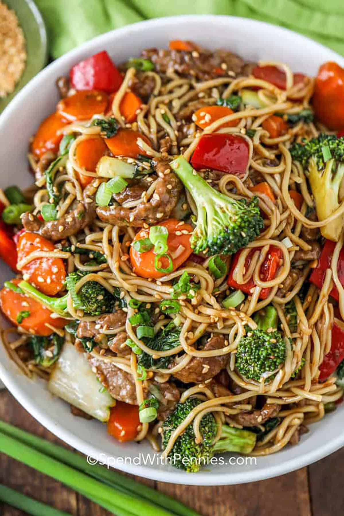 Beef stir fry is a great clean-out-the-fridge dinner with tender steak and plenty of colorful vegetables. Flank or sirloin cooks quickly, while fresh ginger, orange juice, soy sauce, brown sugar, and toasted sesame oil create a rich savory-sweet sauce. Use pre-cut stir fry vegetables when prep time is short and serve everything over rice. Save this beef stir fry recipe for an easy weeknight dinner. #spendwithpennies bowl of Beef Stir Fry.