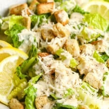 Caesar Salad with lemon slices and croutons .