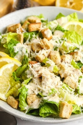 Caesar Salad with lemon slices and croutons .
