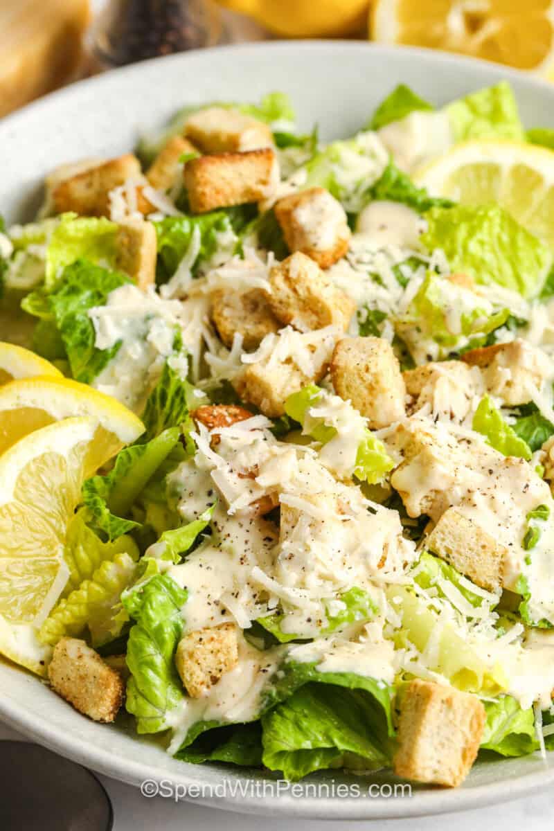 Caesar Salad with lemon slices and croutons .