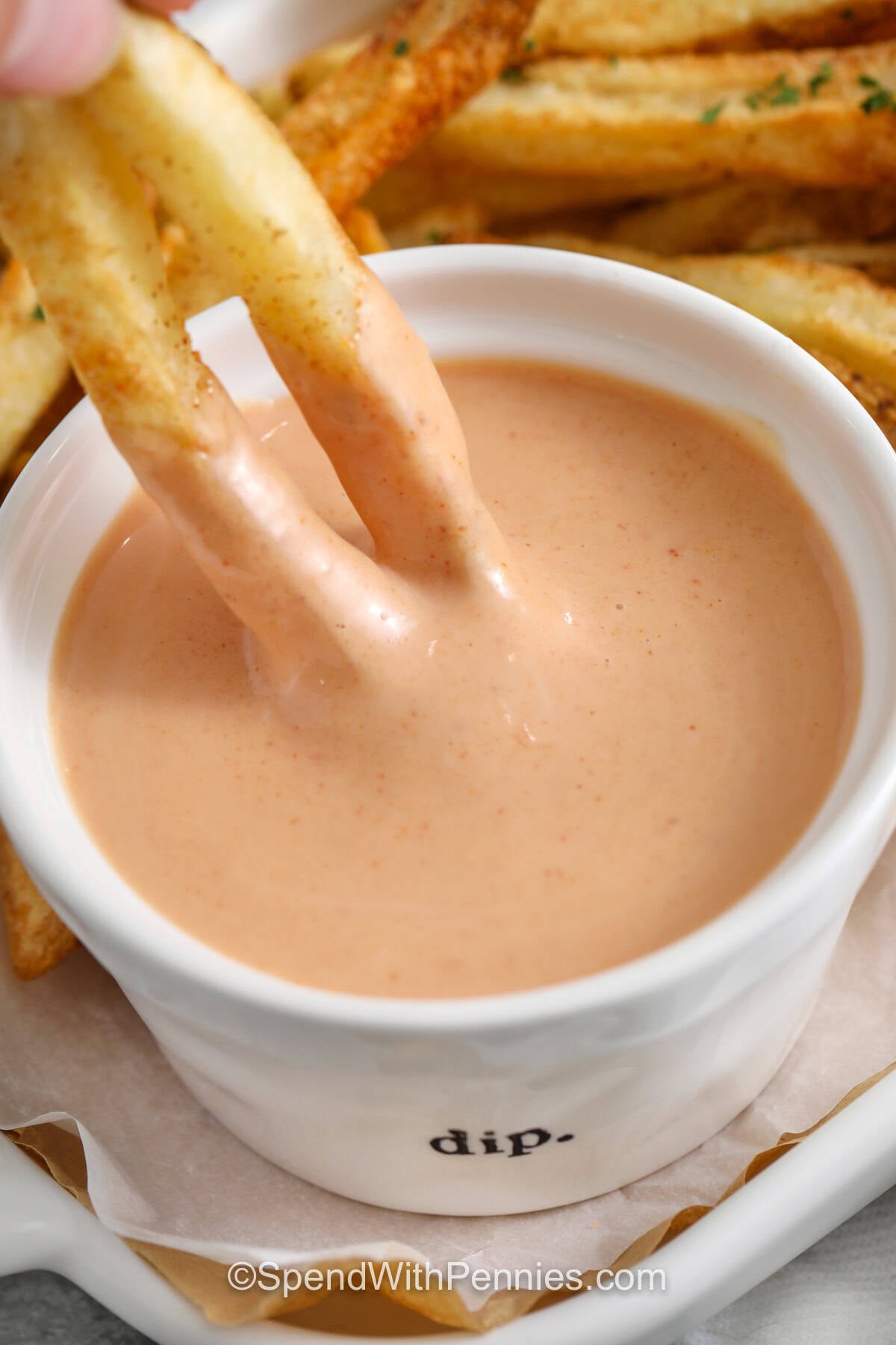This French fry sauce is cool, creamy, slightly sweet, and just tangy enough to pair perfectly with hot, salty fries. The easy mayo and ketchup base gets extra flavor from dill pickle juice and smoked paprika, creating a smooth homemade dip without any complicated ingredients. It also doubles as a tasty spread for burgers and sandwiches. Keep this quick condiment in mind for easy family meals and game-day snacks. Save this French fry sauce recipe to try soon. #spendwithpennies dipping fries in Fry Sauce.
