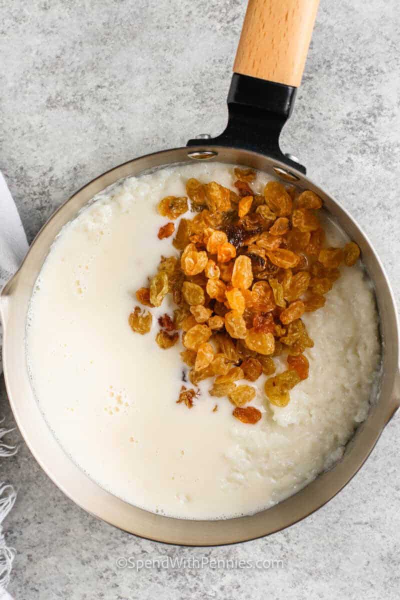 adding raisins to pot to make Homemade Rice Pudding.