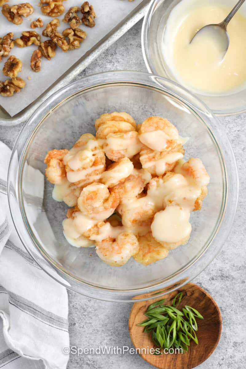 adding sauce to shrimp to make Honey Walnut Shrimp.