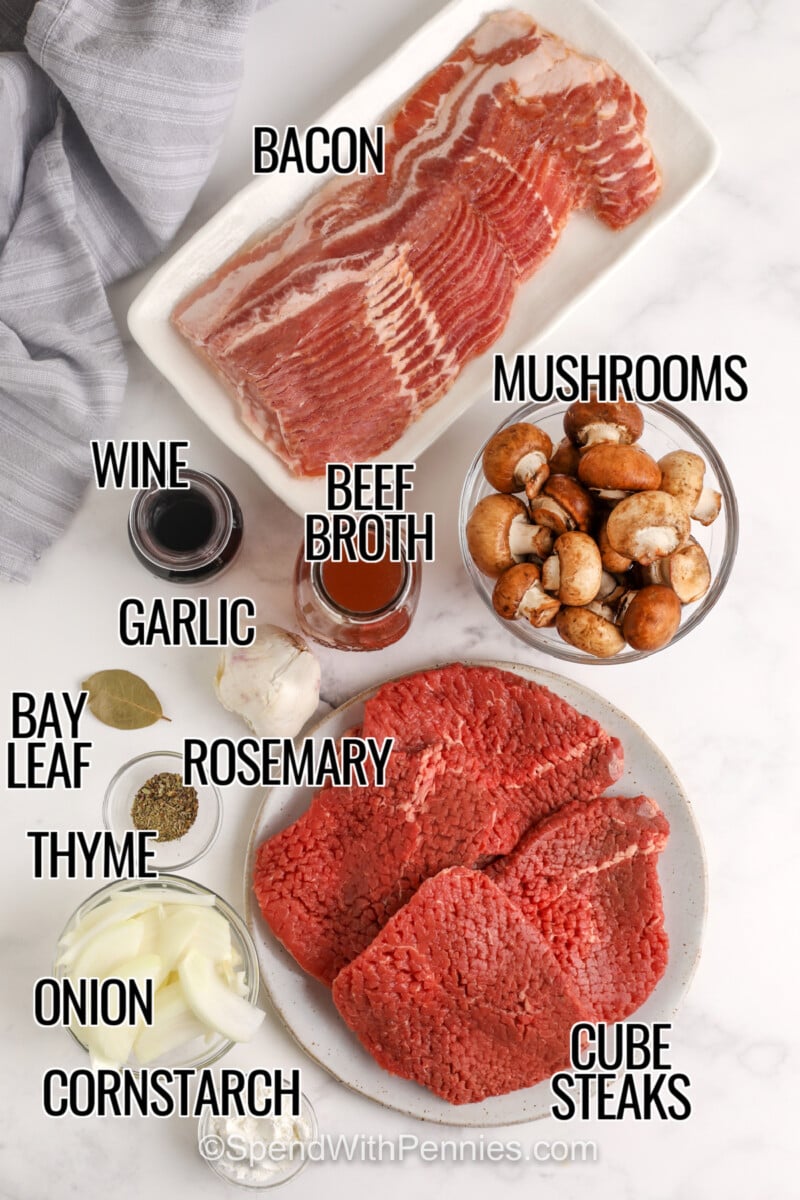 Crock Pot steaks and gravy is a comforting slow cooker dinner that transforms cube steak into fork-tender beef with rich homemade gravy. Bacon, onions, mushrooms, herbs, and beef broth slowly cook together for incredible flavor. Serve over mashed potatoes, egg noodles, or rice for an easy family meal that reheats beautifully. Save this recipe for your next cozy dinner. #spendwithpennies bacon , mushrooms , tomato paste , wine , garlic , rosemary , bay leaf , thyme , onion , cornstarch , cube steaks with labels to make Crock Pot Steak and Gravy