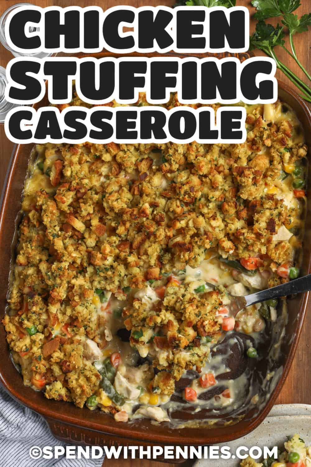 Easy chicken stuffing casserole is a smart way to turn cooked chicken and frozen vegetables into a comforting meal without extra chopping or complicated prep. The creamy chicken filling contrasts with a savory stuffing topping that becomes golden as it bakes. Swap in turkey, another vegetable blend, or a different cream soup to use what is already on hand. Save this chicken stuffing bake for an easy, flexible dinner. #spendwithpennies Chicken Stuffing Casserole in the dish with writing.