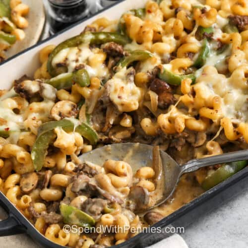 creamy Philly Cheesesteak Casserole in a casserole dish with a spoon.