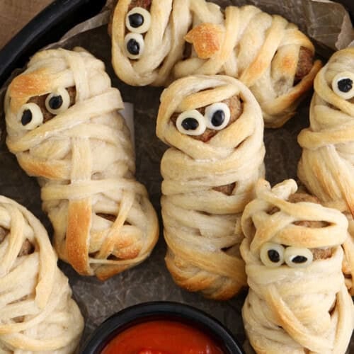 close up of Meatball Mummies on a plate with marinara dip.