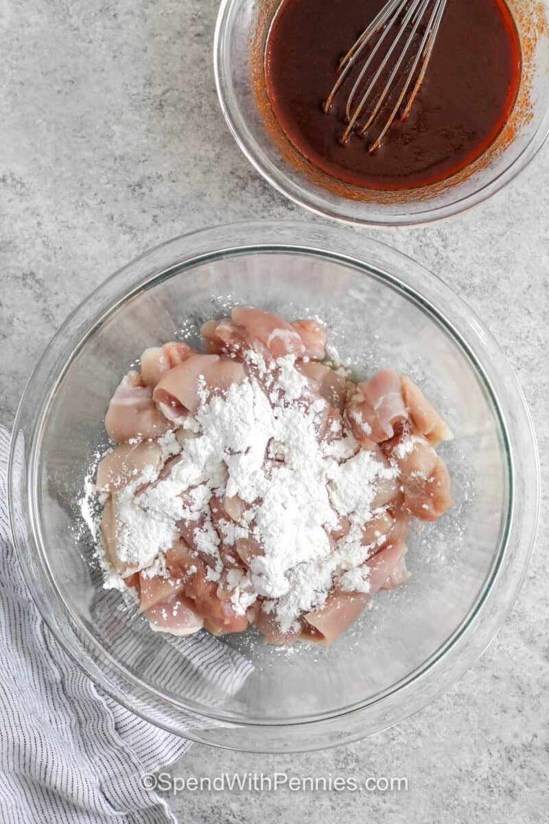 adding cornstarch to chicken to make Gochujang Chicken.