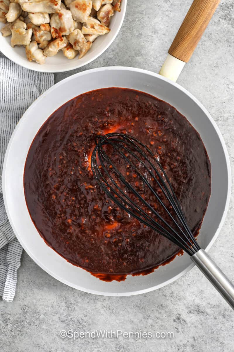 whisking sauce in pan to make Gochujang Chicken.