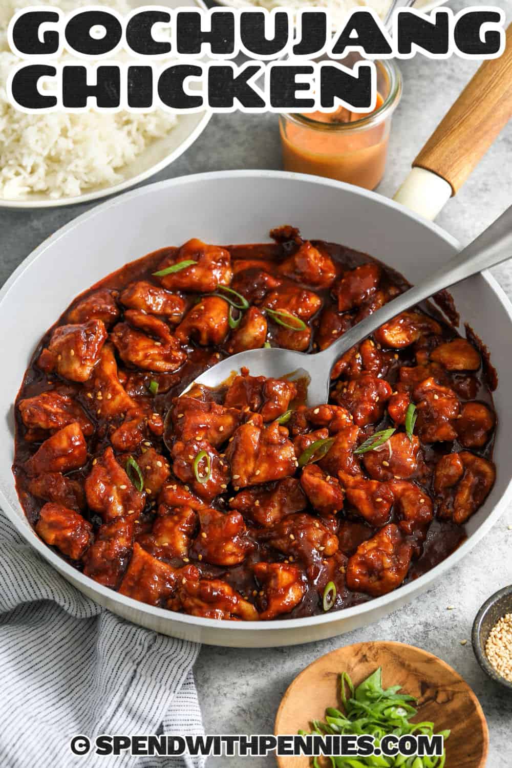 Spicy gochujang chicken thighs are an easy option when you want a saucy skillet dinner without deep frying or a long marinade. Browning the chicken in smaller batches gives it better color, then the gochujang and honey sauce thickens quickly in the same pan. Garlic, ginger, sesame oil, and rice vinegar round out every bite with savory, tangy flavor. Serve with hot rice for a comforting meal. Pin this recipe for an easy dinner night. #spendwithpennies pan of Gochujang Chicken with a title.