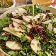 Thanksgiving salad in a bowl with a far of dressing.